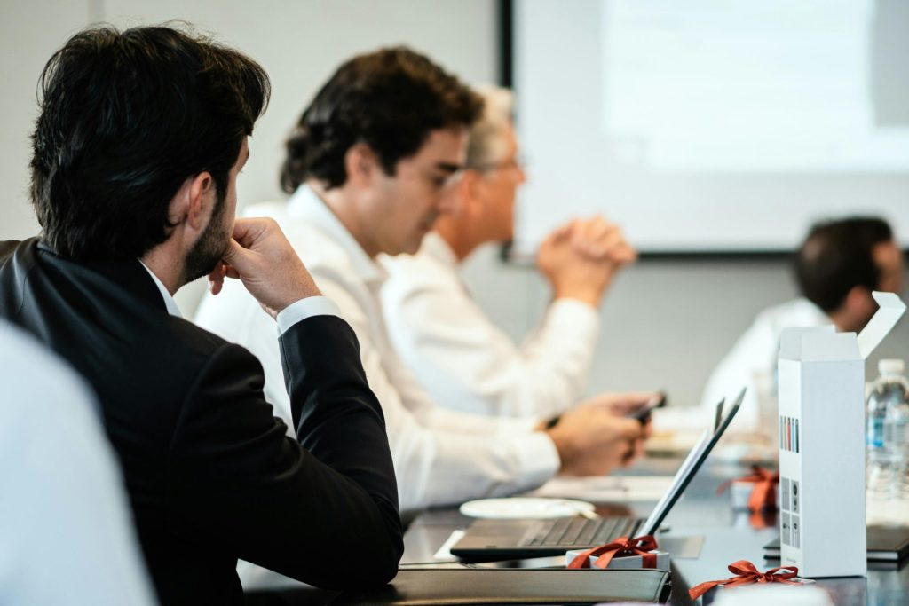 Professionelle Mitarbeiter in einem formellen Meetingumfeld, mit Fokus auf Teamarbeit und Zusammenarbeit.